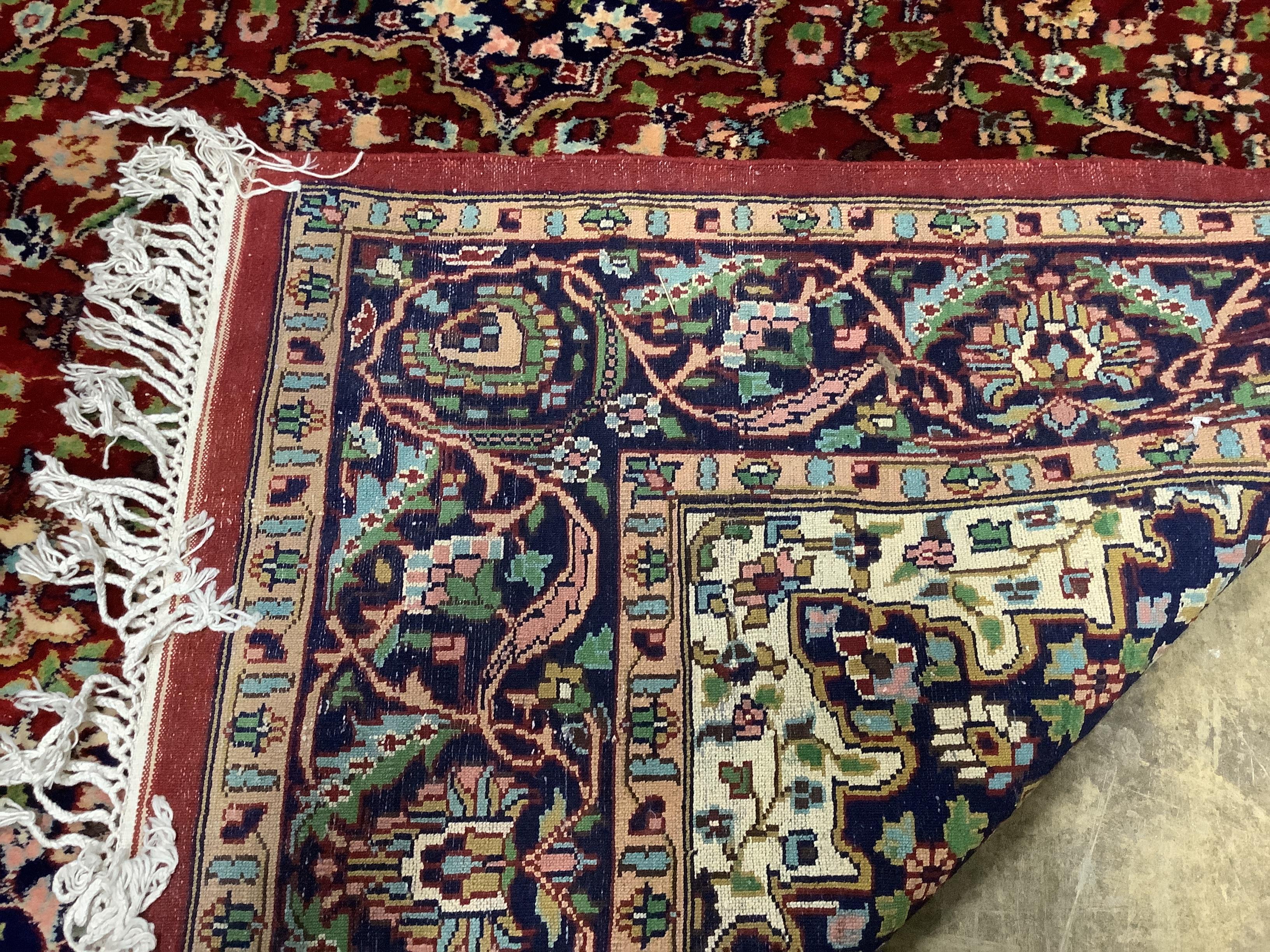 A Tabriz style burgundy ground rug, 224 x 155cm